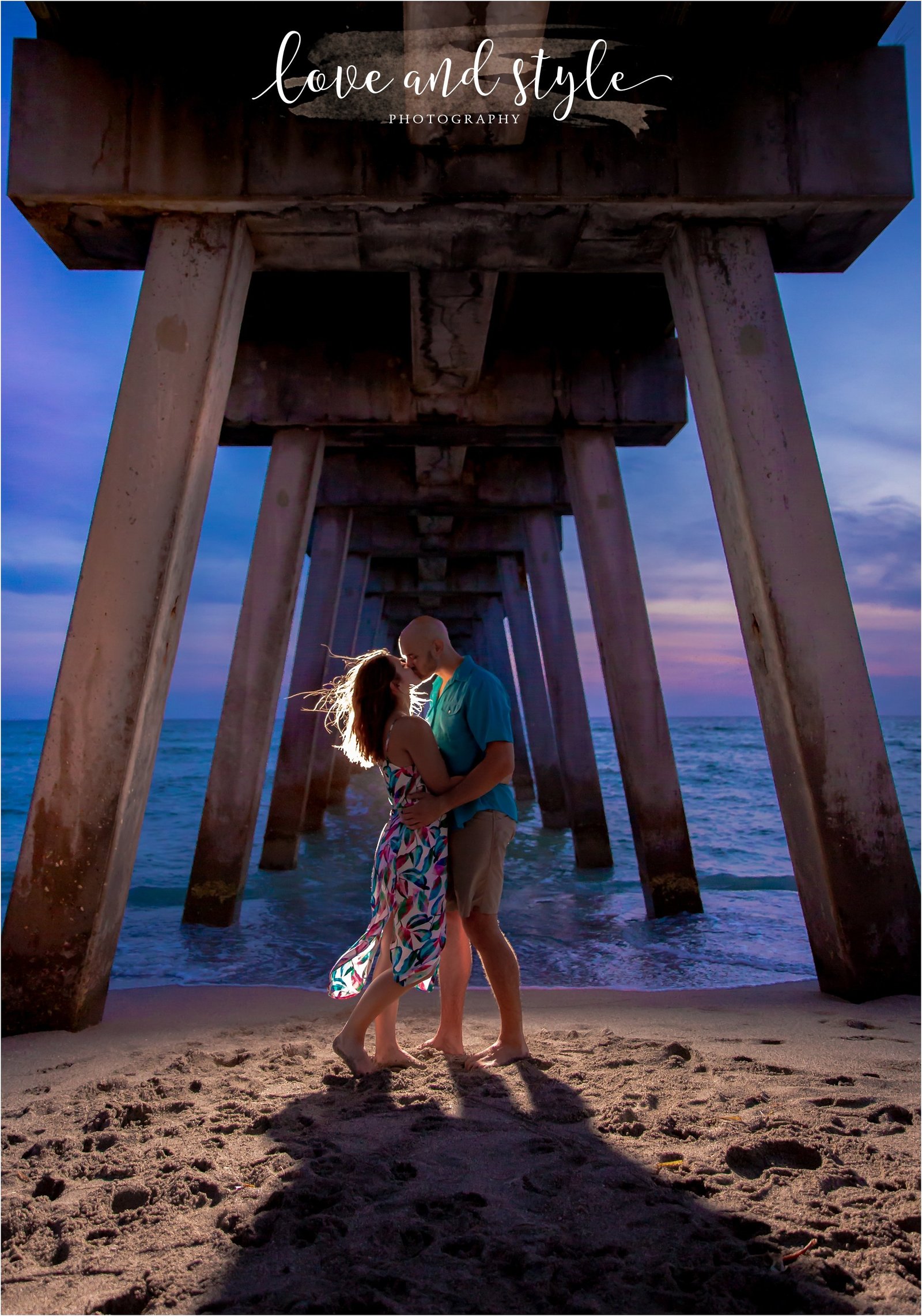 Engagement Photography on Venice Dog Beach under the pier with backlight and couple kissing