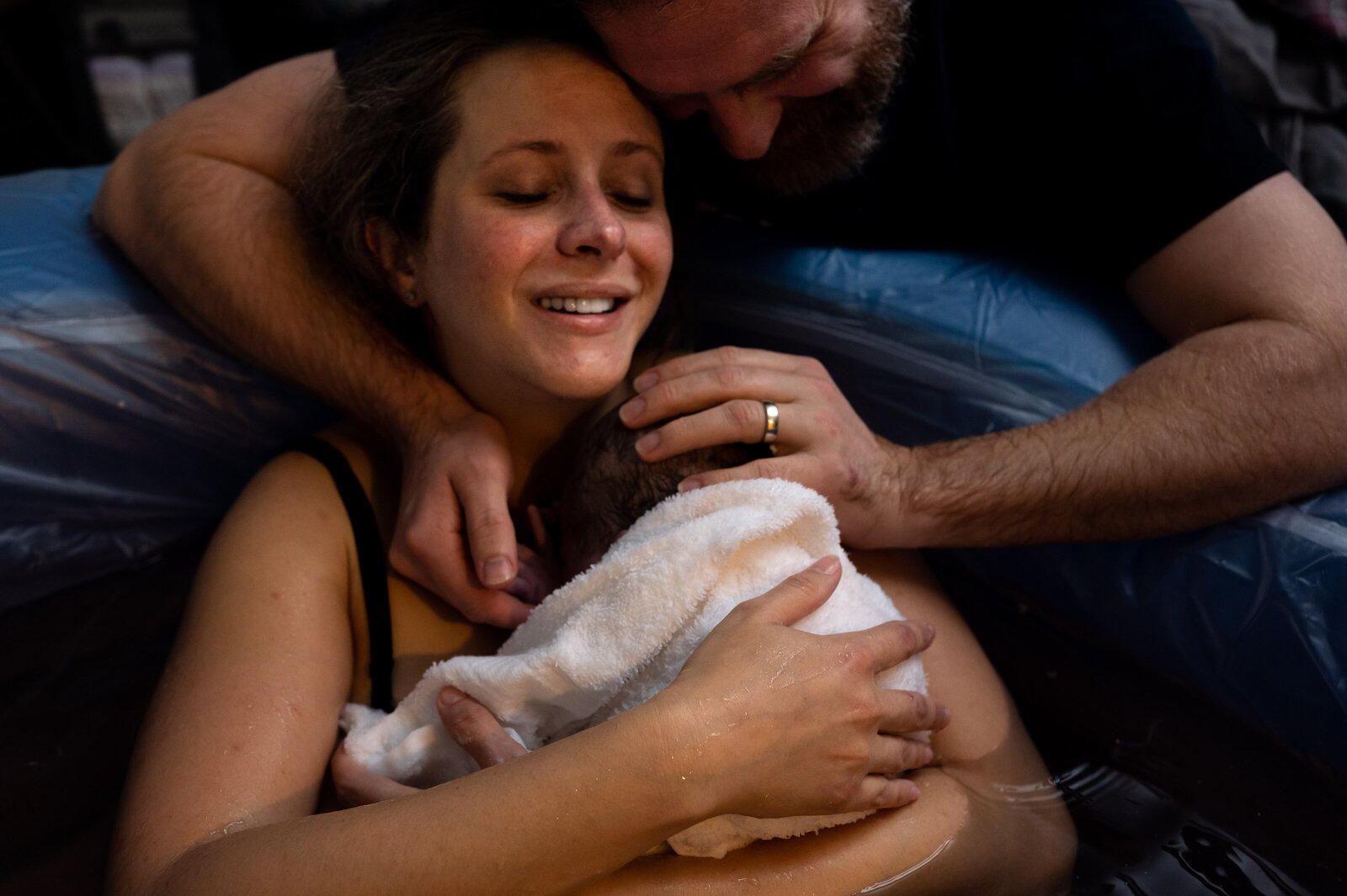 parents smile over newborn baby