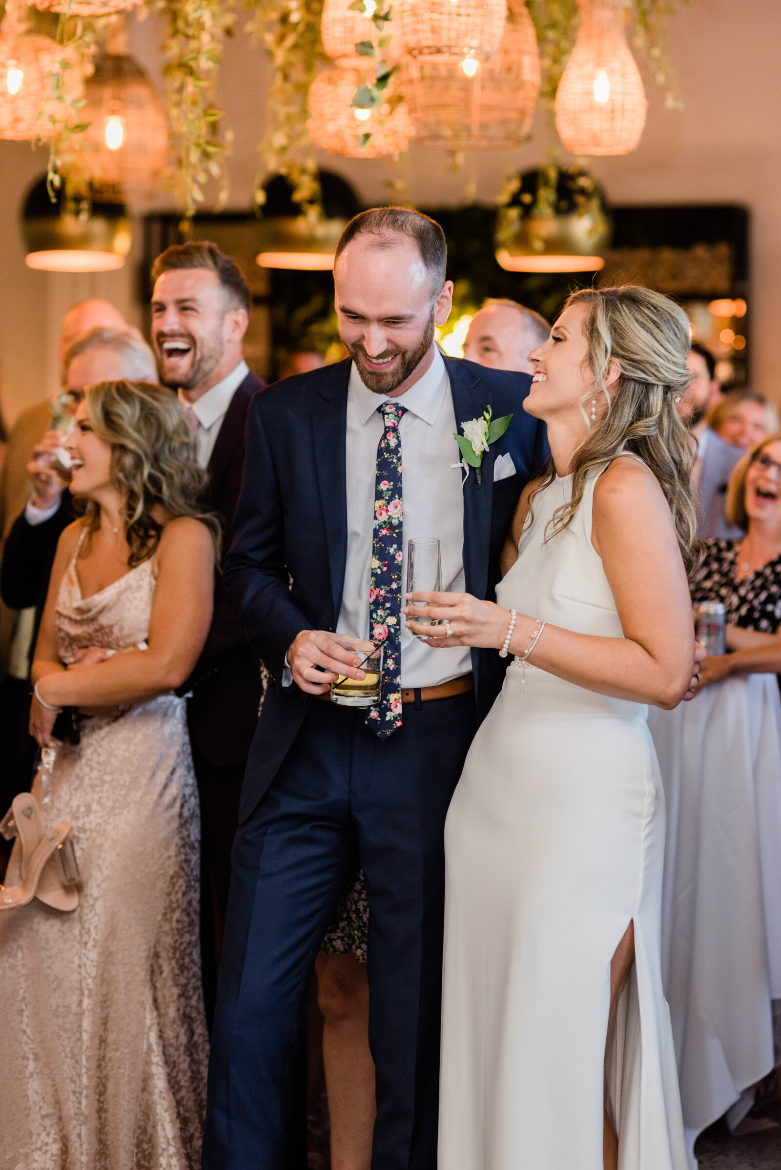 Wedding couple laughing and holding drinks