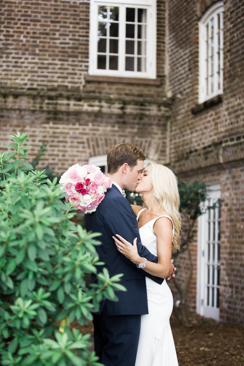 Bride and groom snuggle at the Rice Mill Building, Charleston, South Carolina. Kate Timbers Photography.