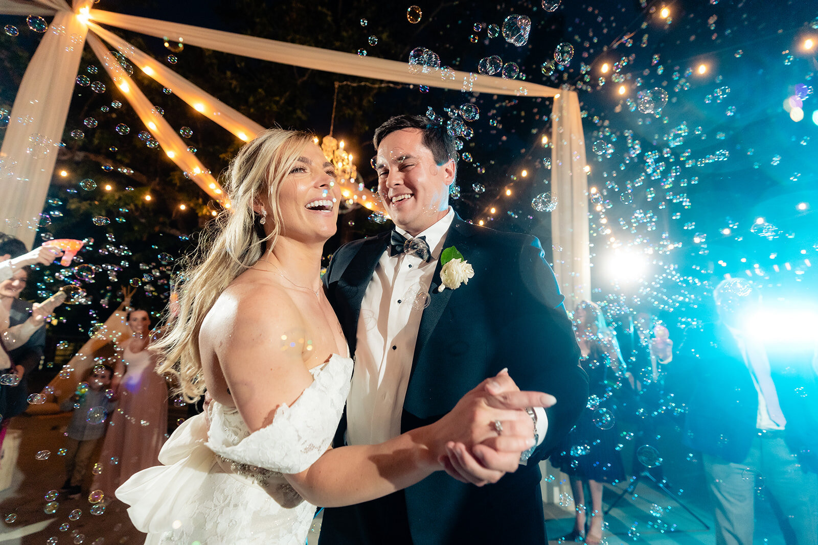 A bride and groom dancing with many bubbles floating around them on the dance floor