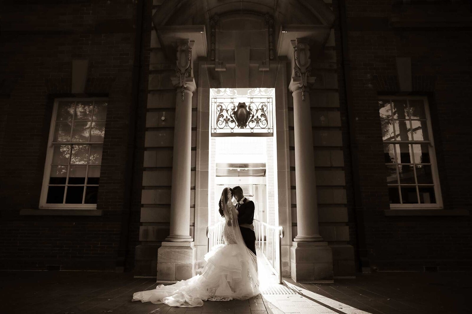Bride and groom in doorway backlit