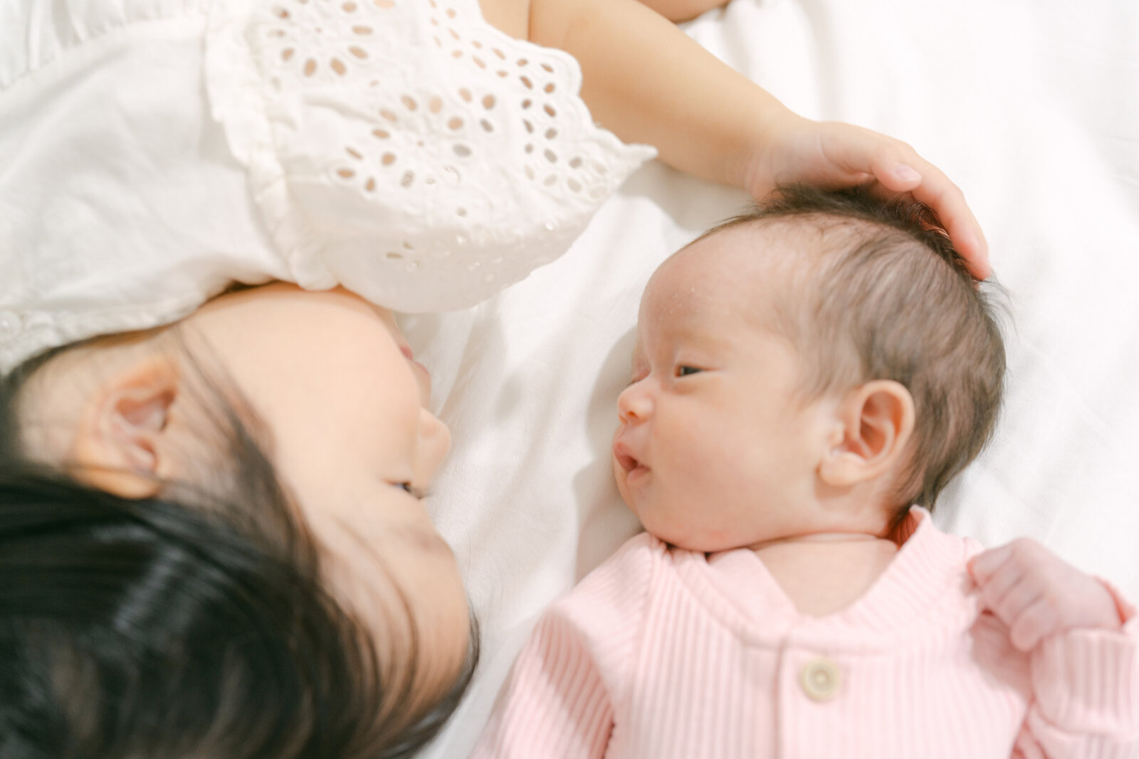 newborn baby girl with toddler sister