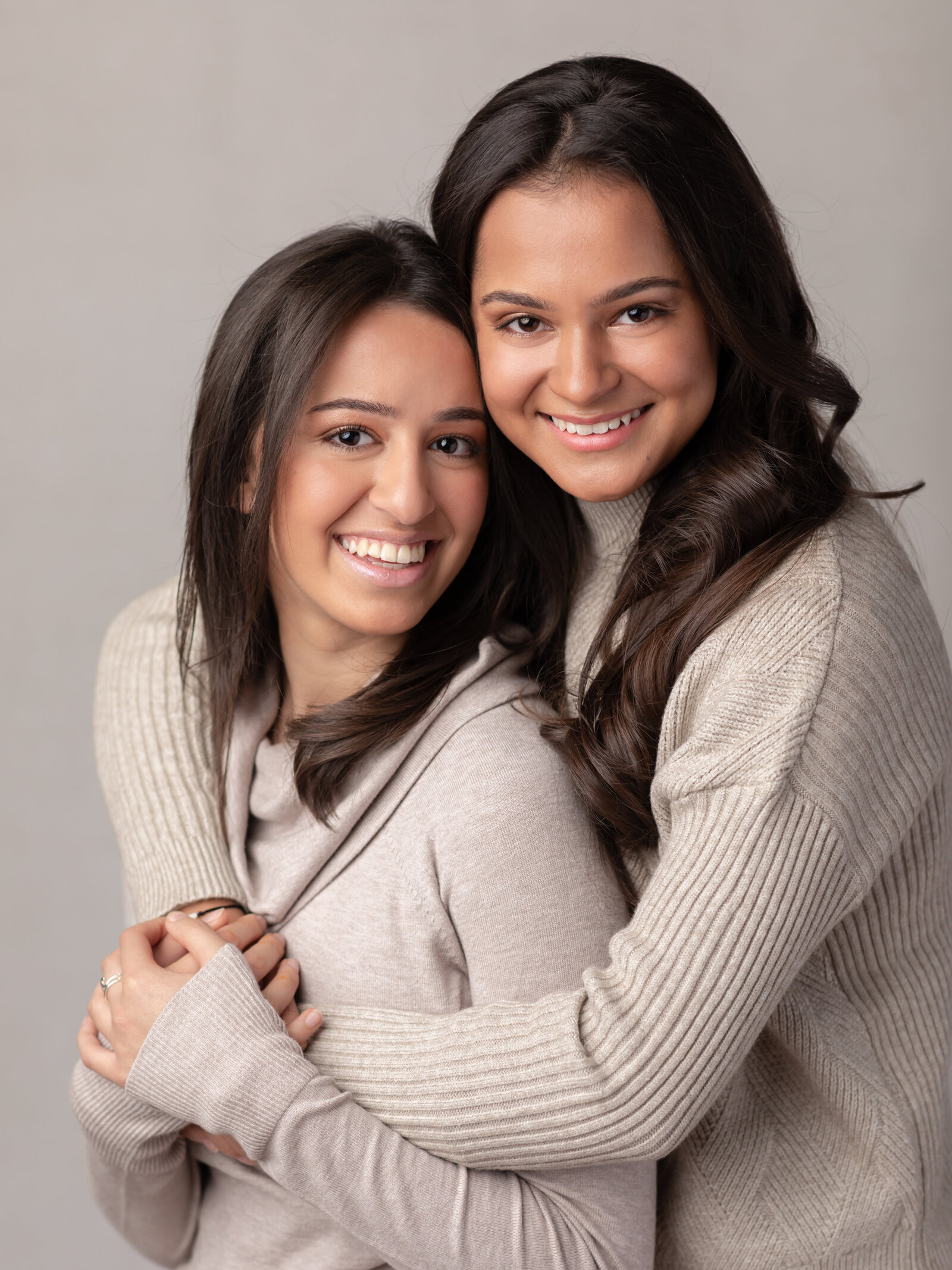 sisters hugging for studio family portraits