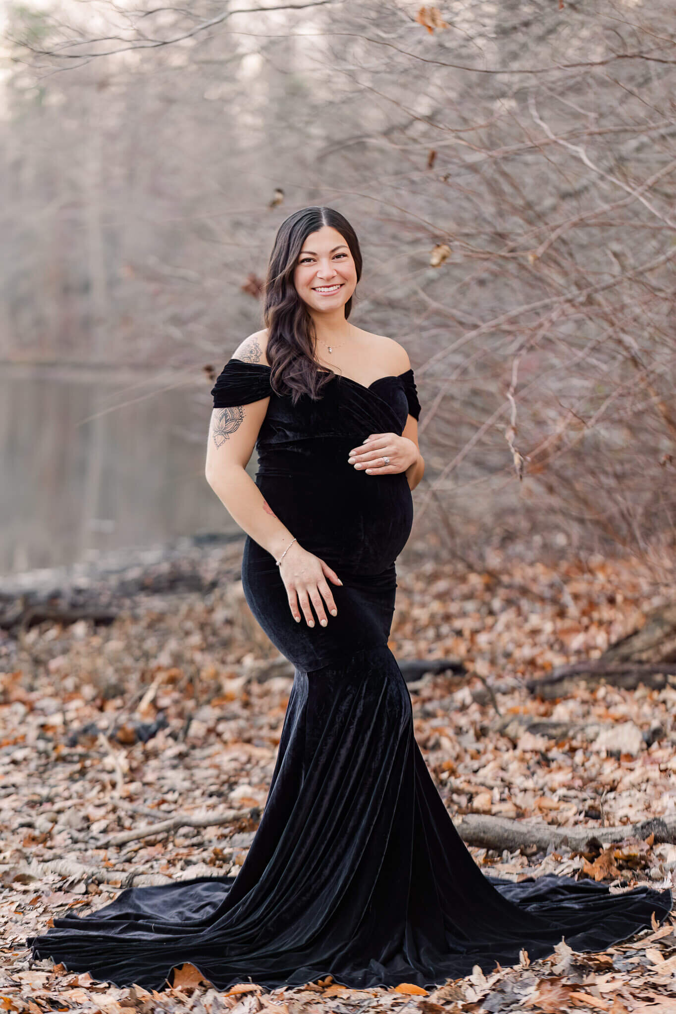 A beautiful mother-to-be in a black dress posing for her Burke, Virginia maternity portraits.