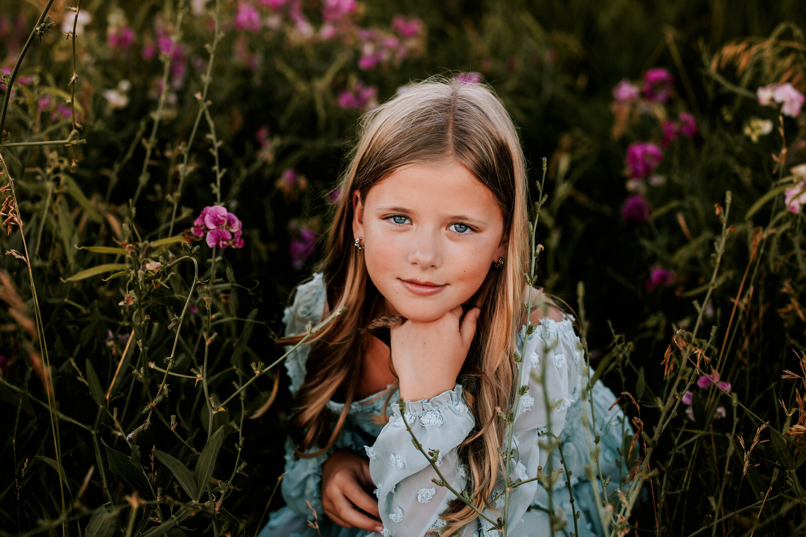 young girl poses in bed of purple flowerss