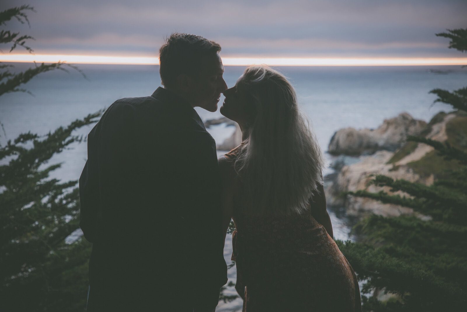 Silhouette of couple almost kissing during sunset in Big Sur.
