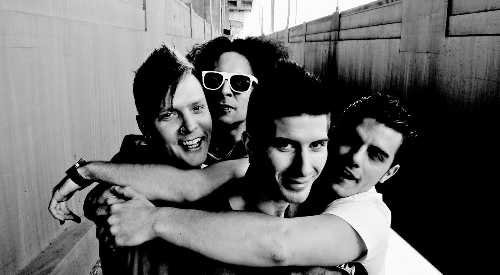 Band portrait Los Angeles Faber Drive group members arms wrapped around each other black and white