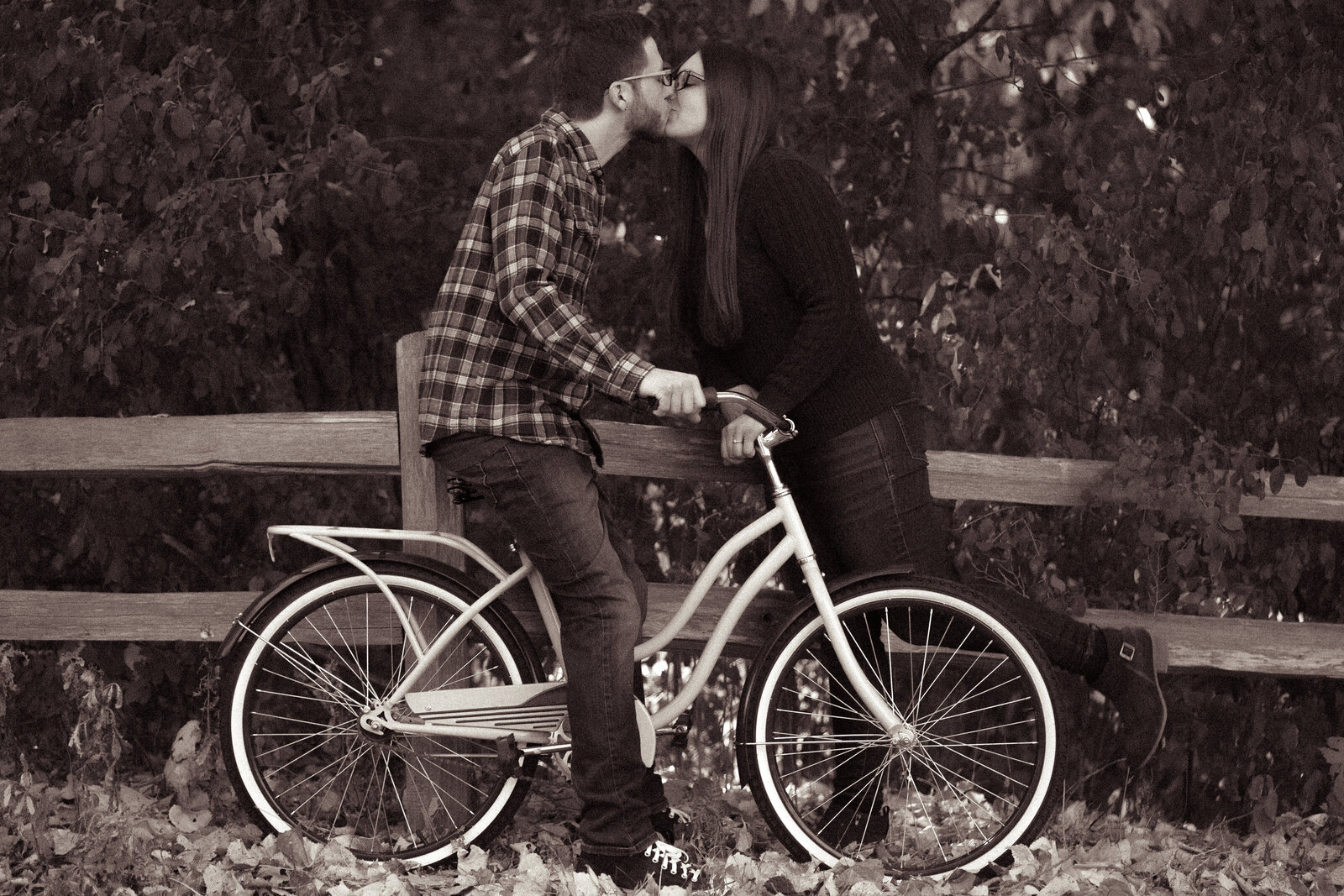 Couple kissing on a bike in the fall