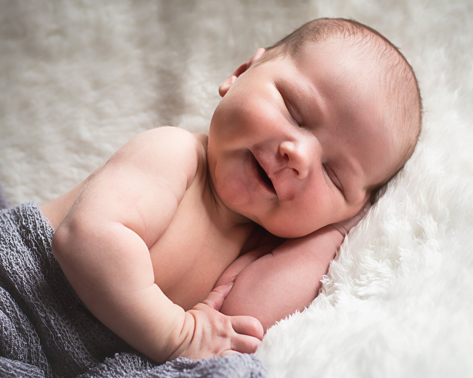 Newborn boy sleeping during in-home newborn photo session.