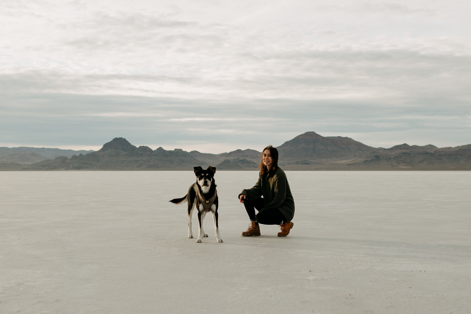Destination wedding photographer posing at the Bonneville Salt Flats in Utah with her dog