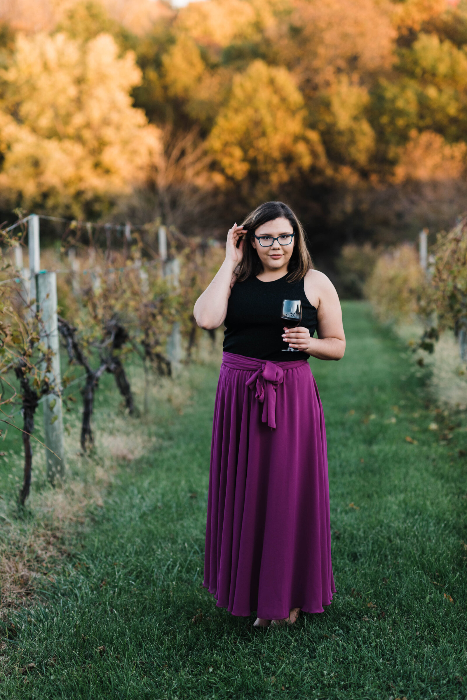 Girl holding wine in vineyard