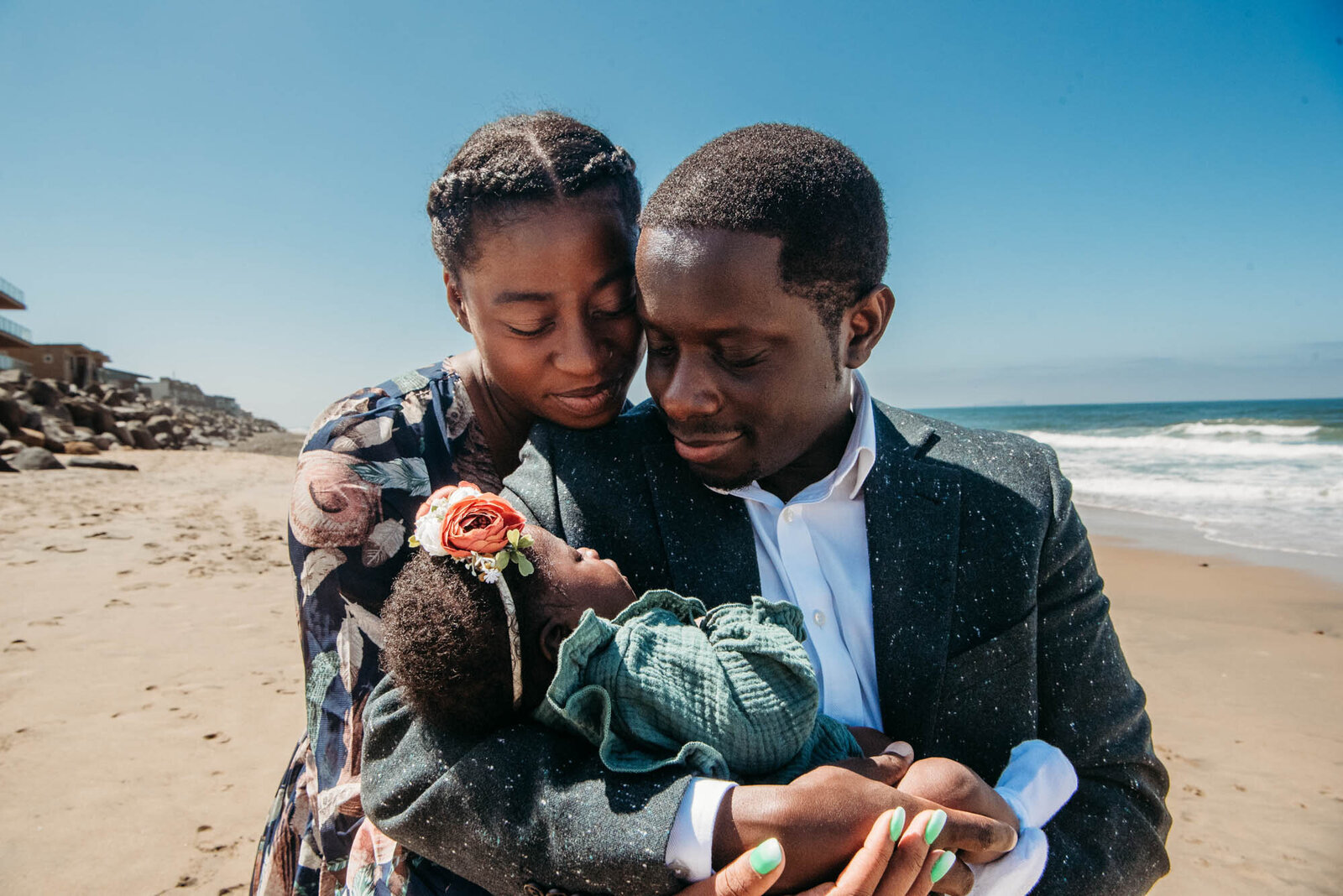 Parents gaze at their newborn girl on a San Diego beach