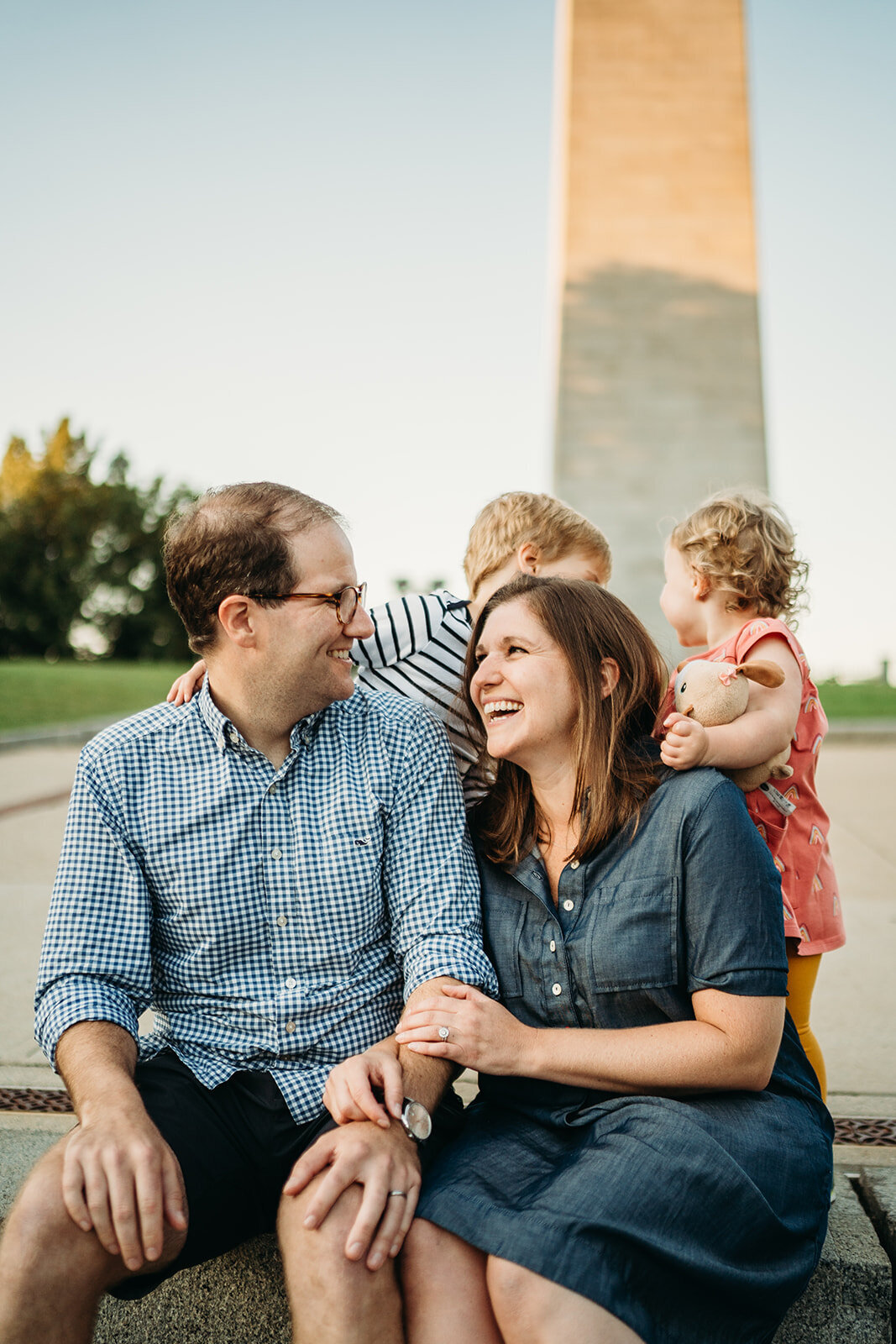 parents smile at each other in front of bunker hill monument