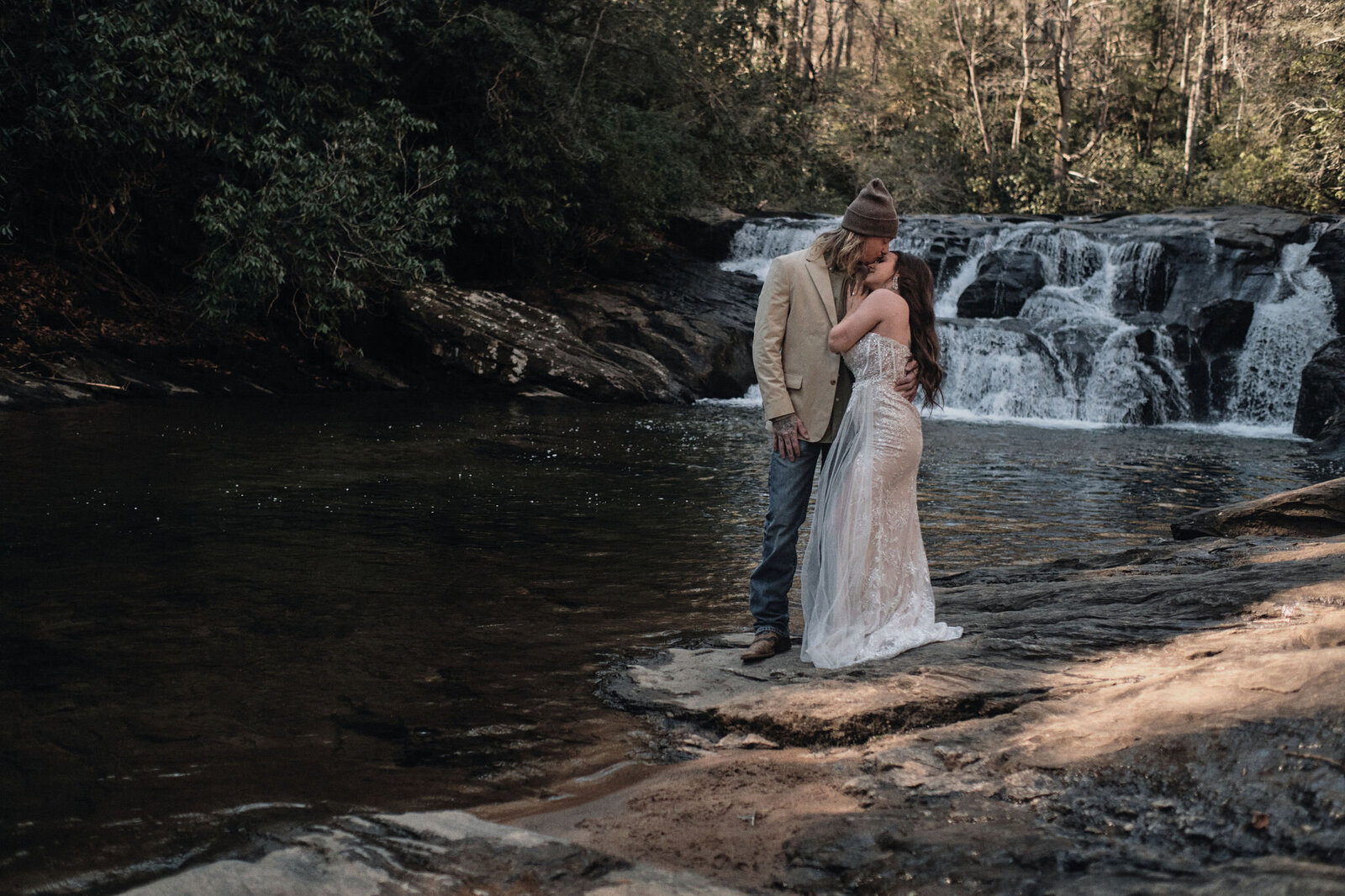 Eloping couple beneath a waterfall