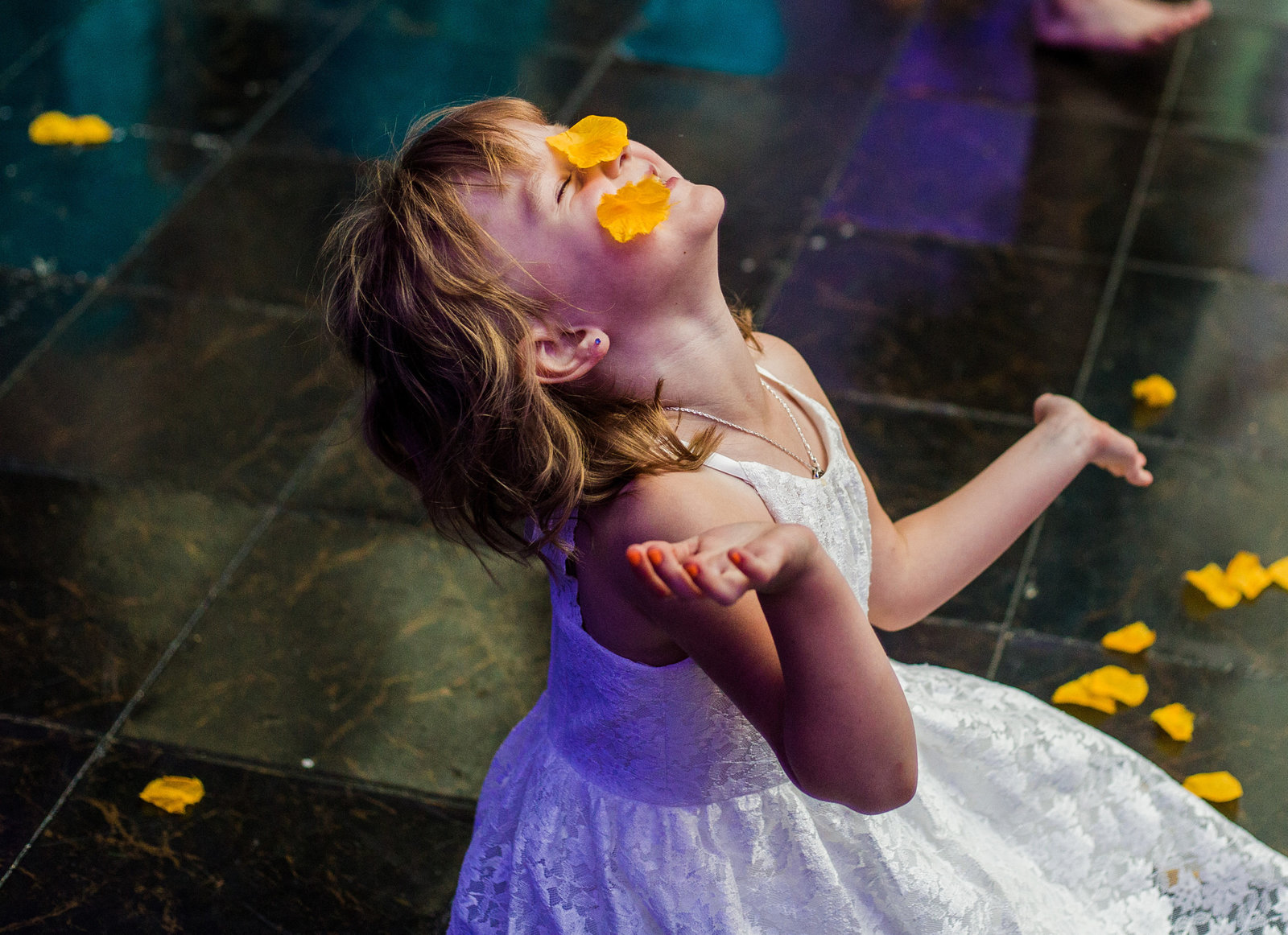 Child plays with flower petals during wedding reception at the Concourse at Union Station
