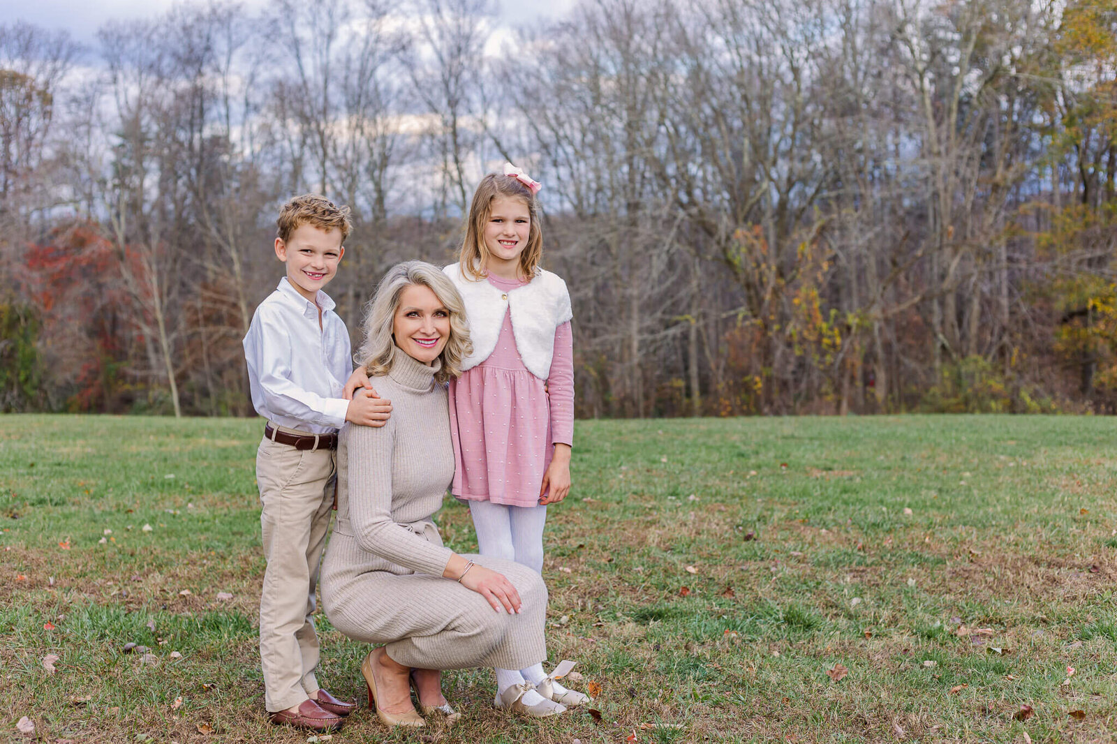 A mom and her two kids posing in a field during a Burke family photography session.