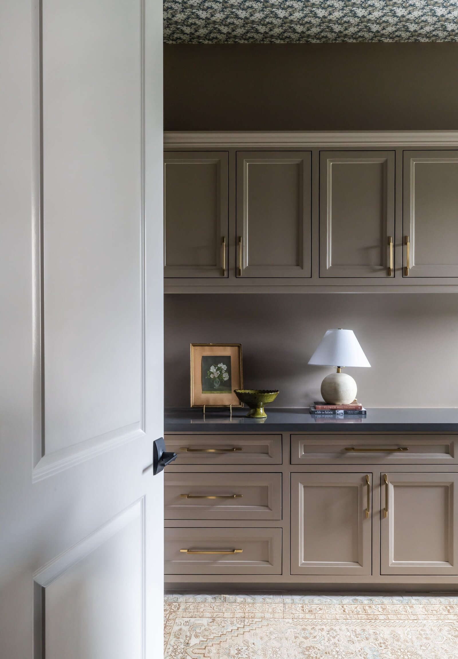 vision and hammer tan cabinets with lamp and picture frame on counter