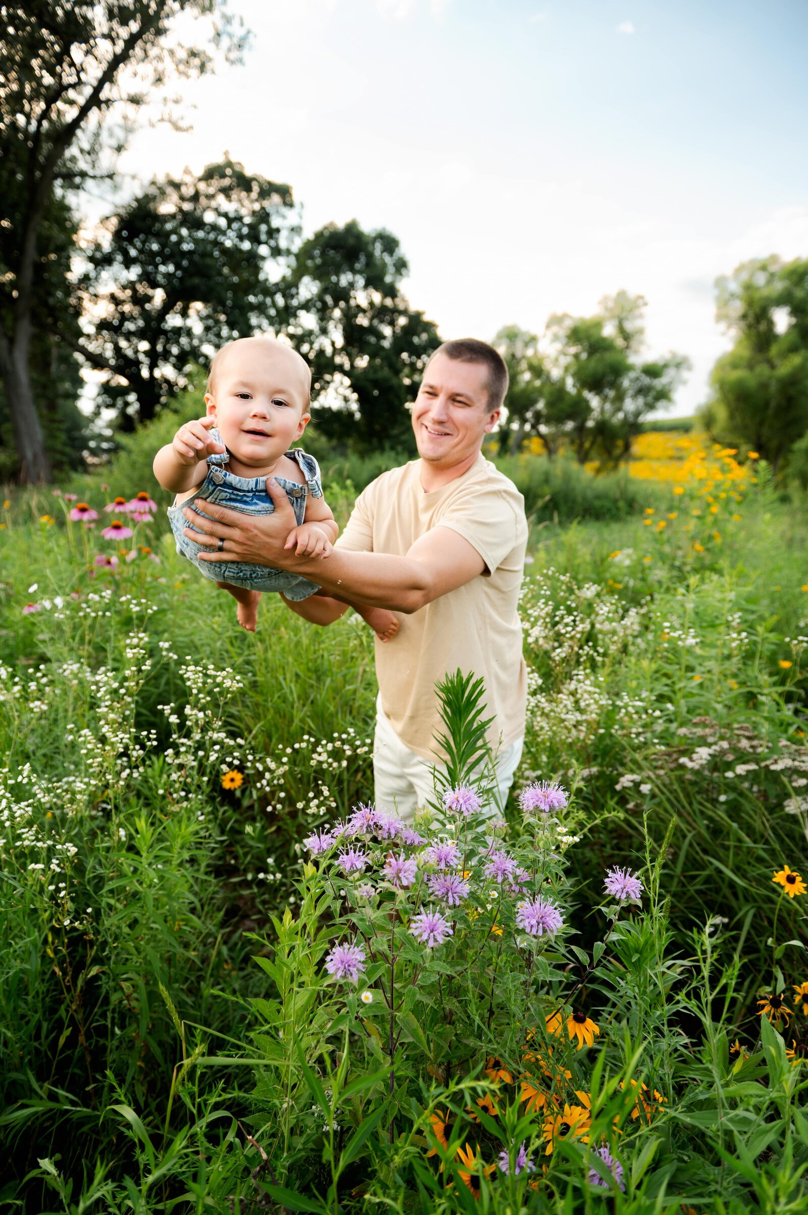 dad playing airplane with his son in a flower field in Maryland