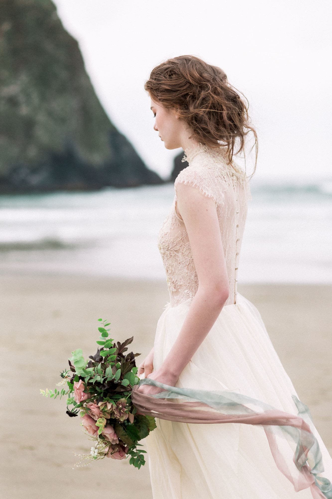 Bride at Cannon Beach during a rainy Oregon coast elopement