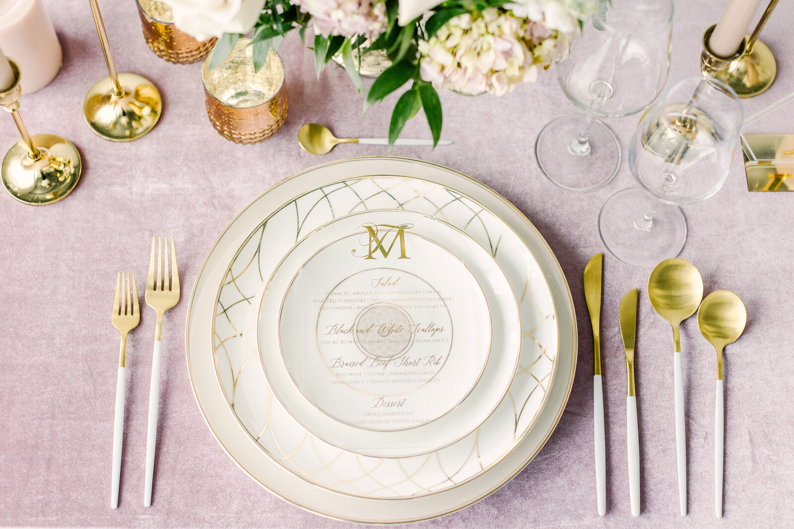 white and gold wedding plating with the letters J and M engraved on the plates