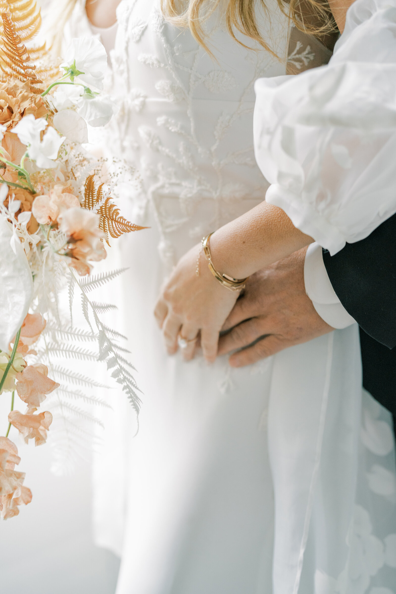 bride and groom holding hands with with bouquet