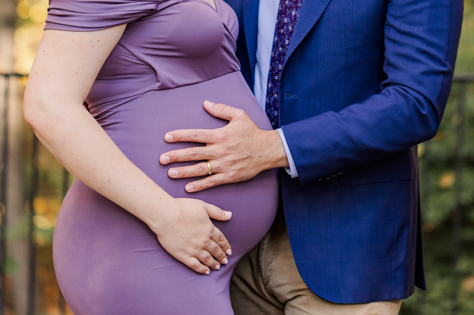 A close-up of an expecting couple holding the belly for their maternity portraits in Centreville, Virginia.