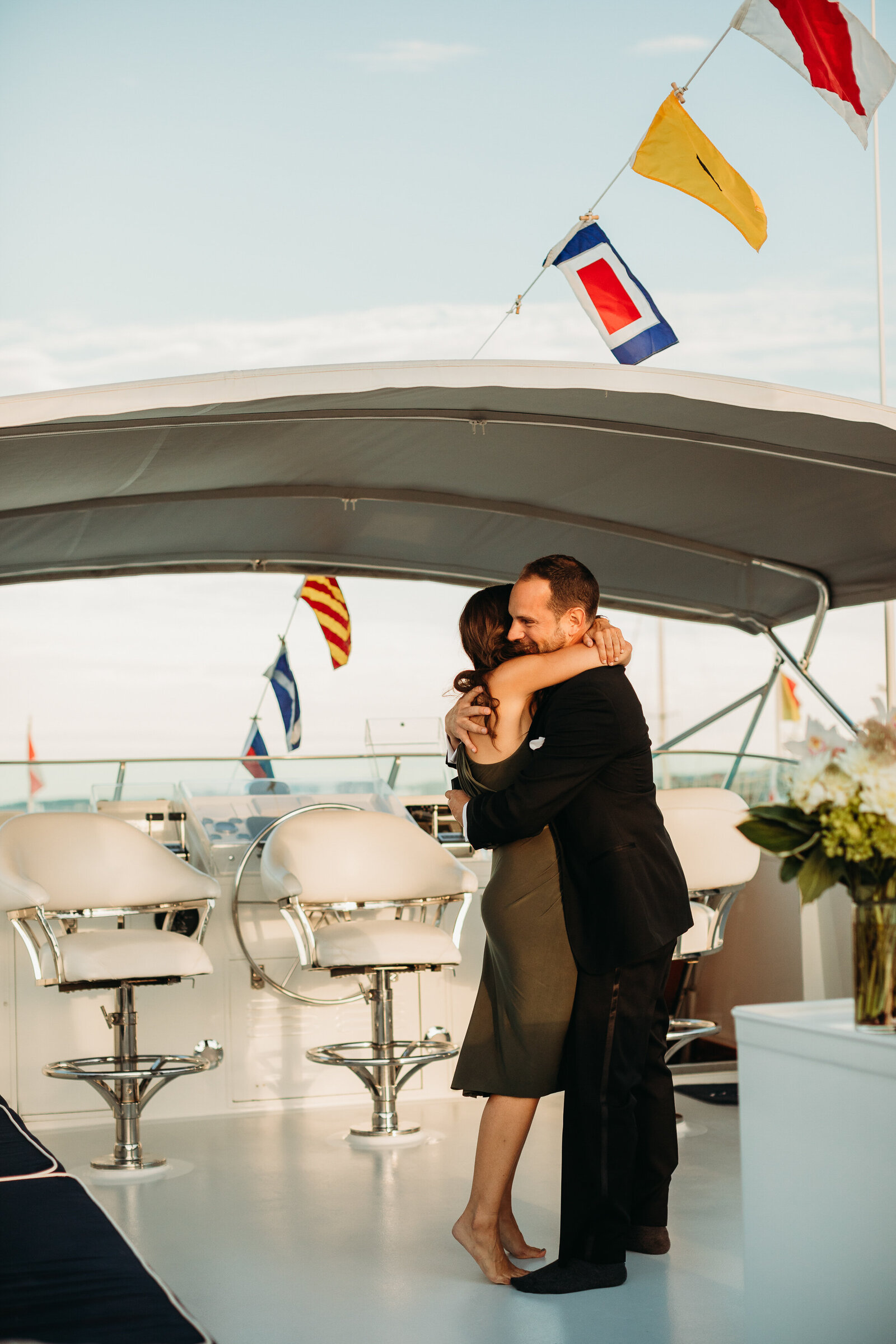 couple embrace after proposal onboard a yacht
