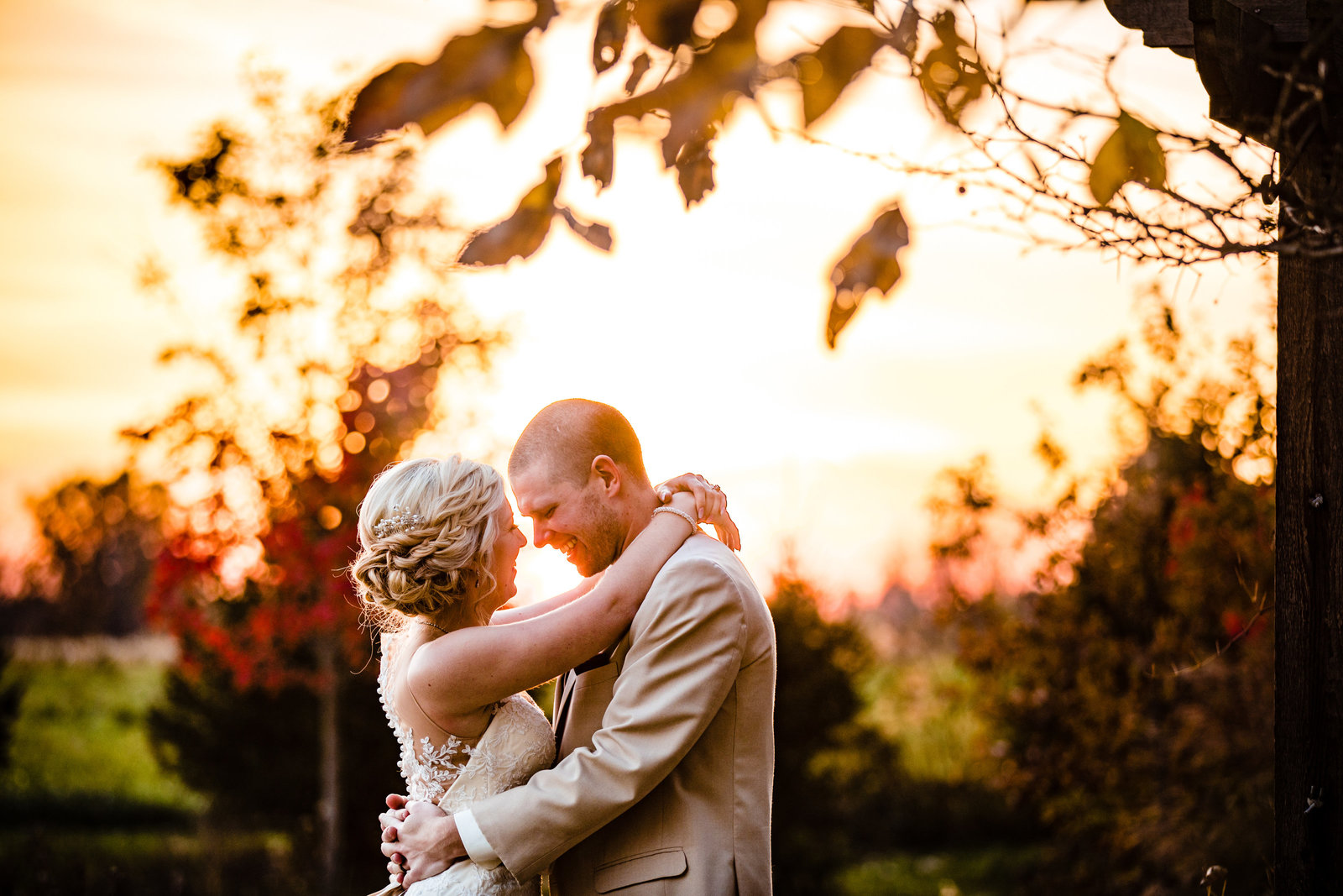 wedding photo of a bride and groom hugging in front of a sunset at Brookshire wedding venue