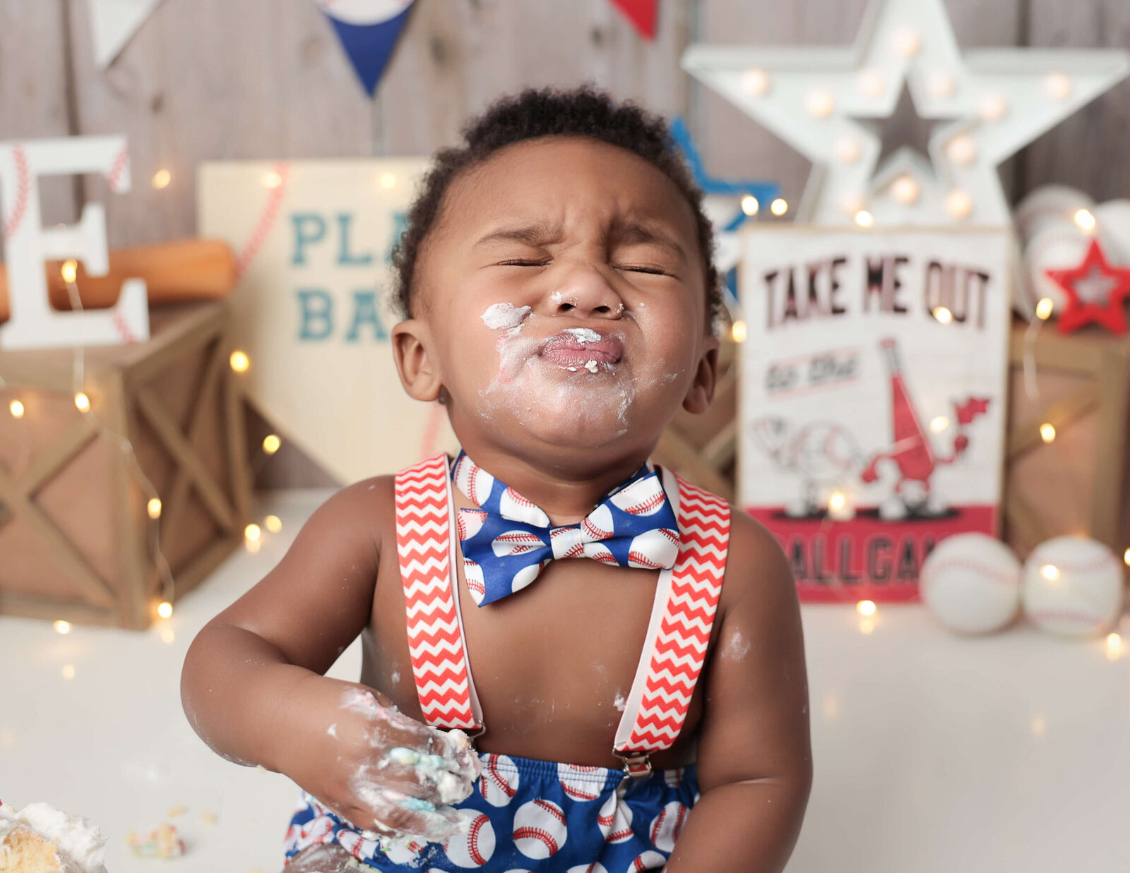 Little boy scrunching his nose at our baseball Rochester Ny cake smash studio.