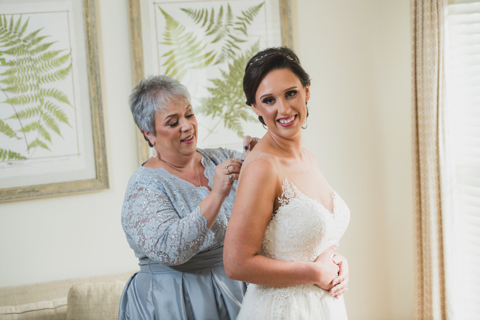 photo of mom helping bride with bridal dress from wedding at Three Village Inn