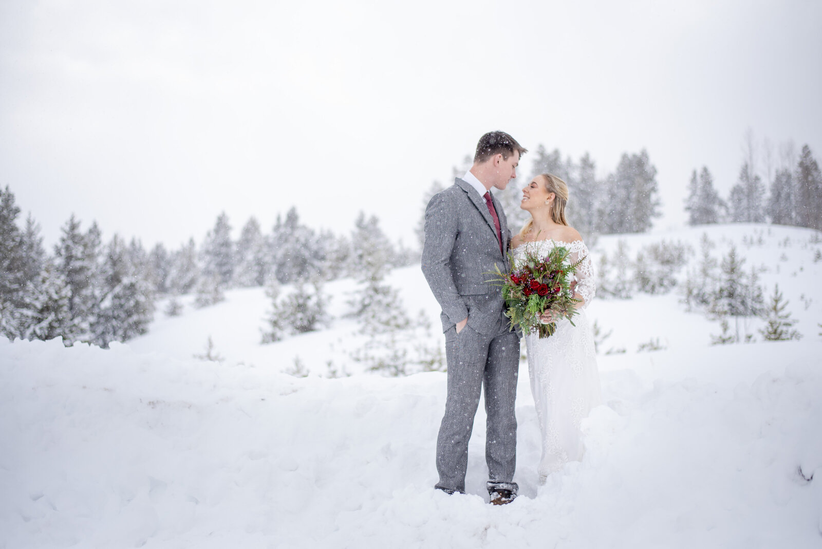 Newlyweds cuddling deep in the rocky mountains during winter