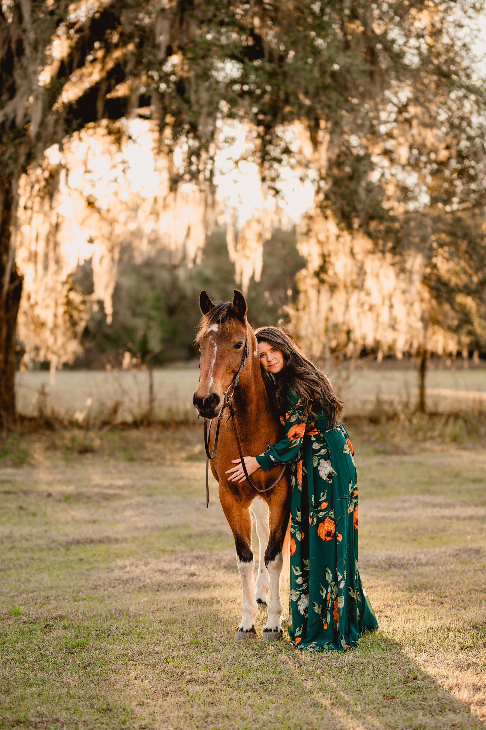 Woman with her paint mare under an Oak tree at sunset in Tallahassee, FL.