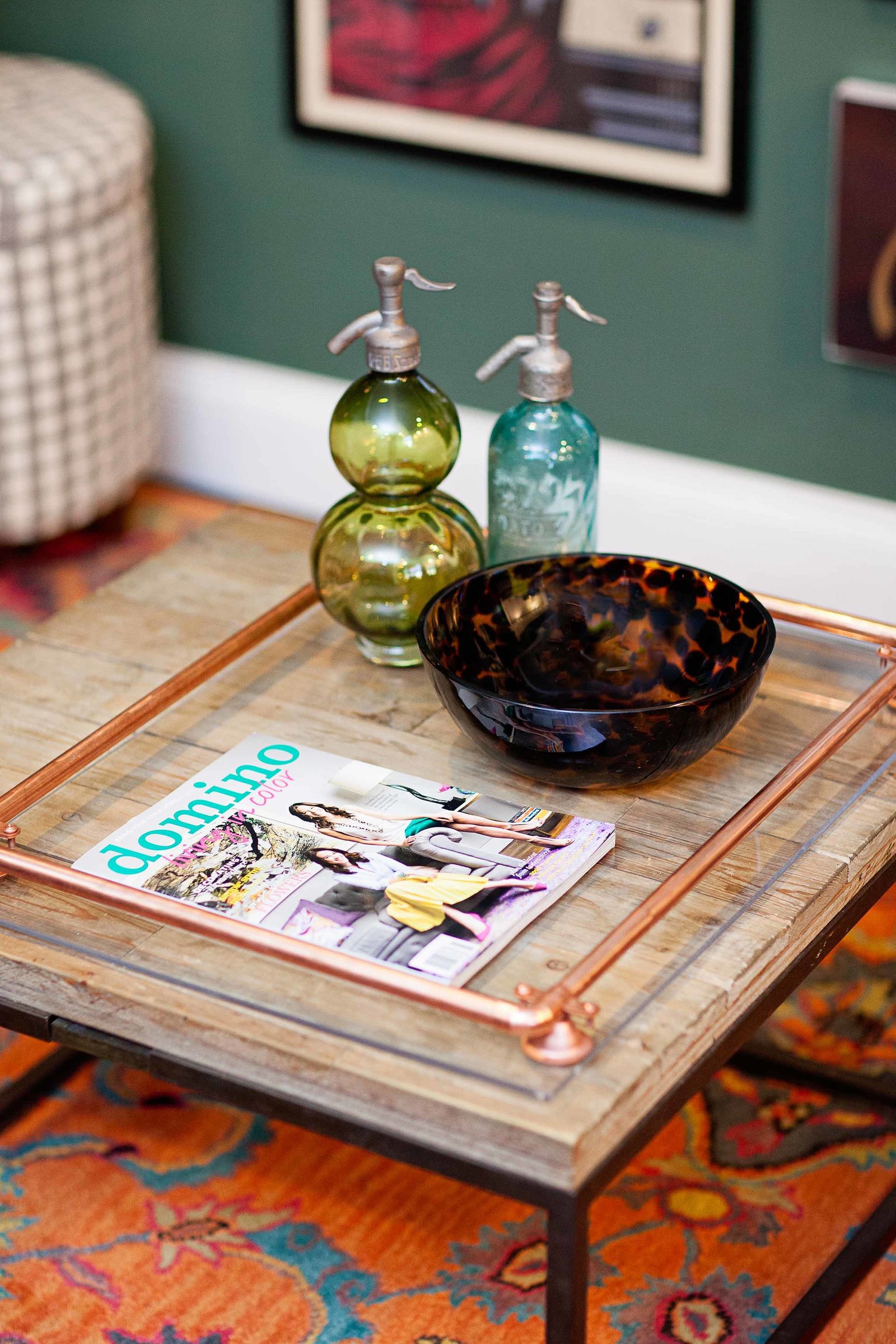 A coffee table with glass dishes and a domino magazine.