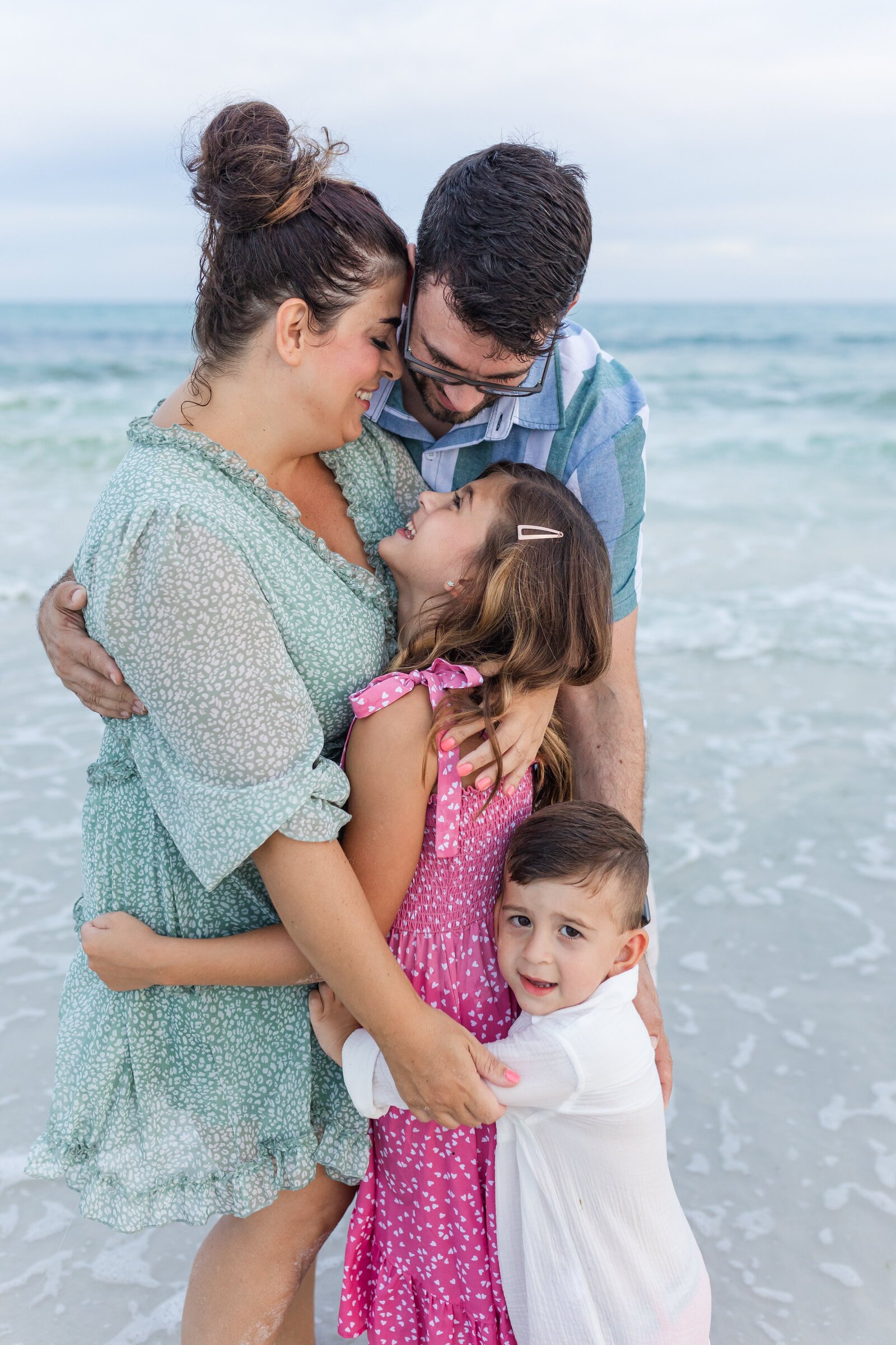 Pensacola Beach vacation family photo session .  Family group hug photo on the beach.