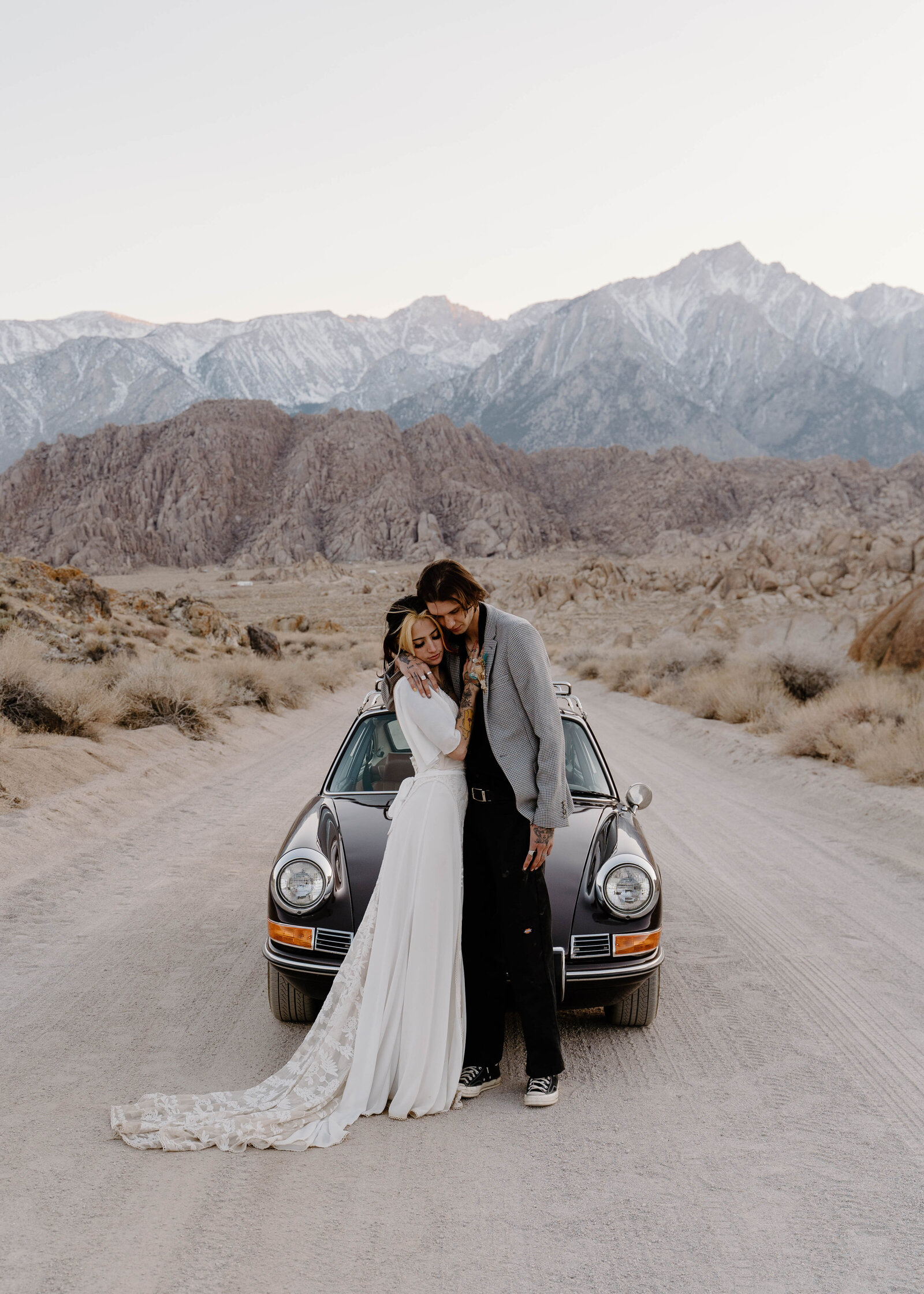 Dreamy sunset elopement photos in Lone Pine, California featuring a young, edgy couple with a vintage porsche car