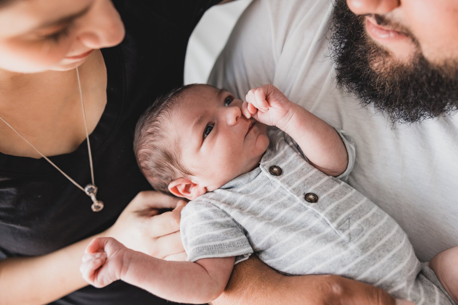 New parents holding newborn son during lifestyle newborn photo session in Pensacola, FL