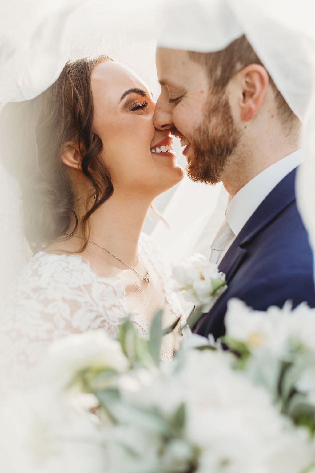 bride and groom on their wedding day romantic portrait light and airy burgundy flowers gray suit