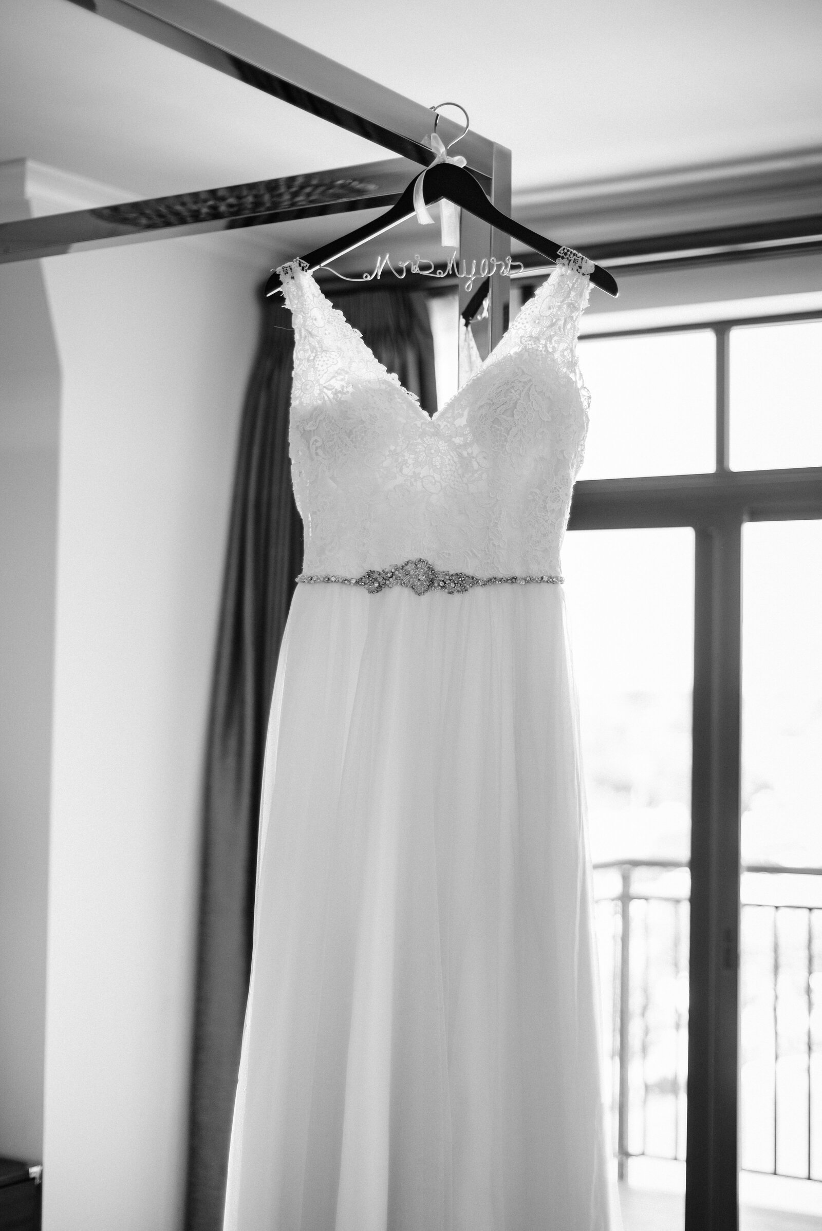 black and white image of a dress hanging in front of a window