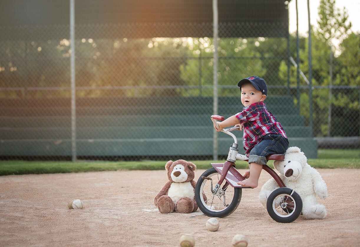 12 month old boy at 1st birthday photoshoot on baseball field in Austin, Tx.