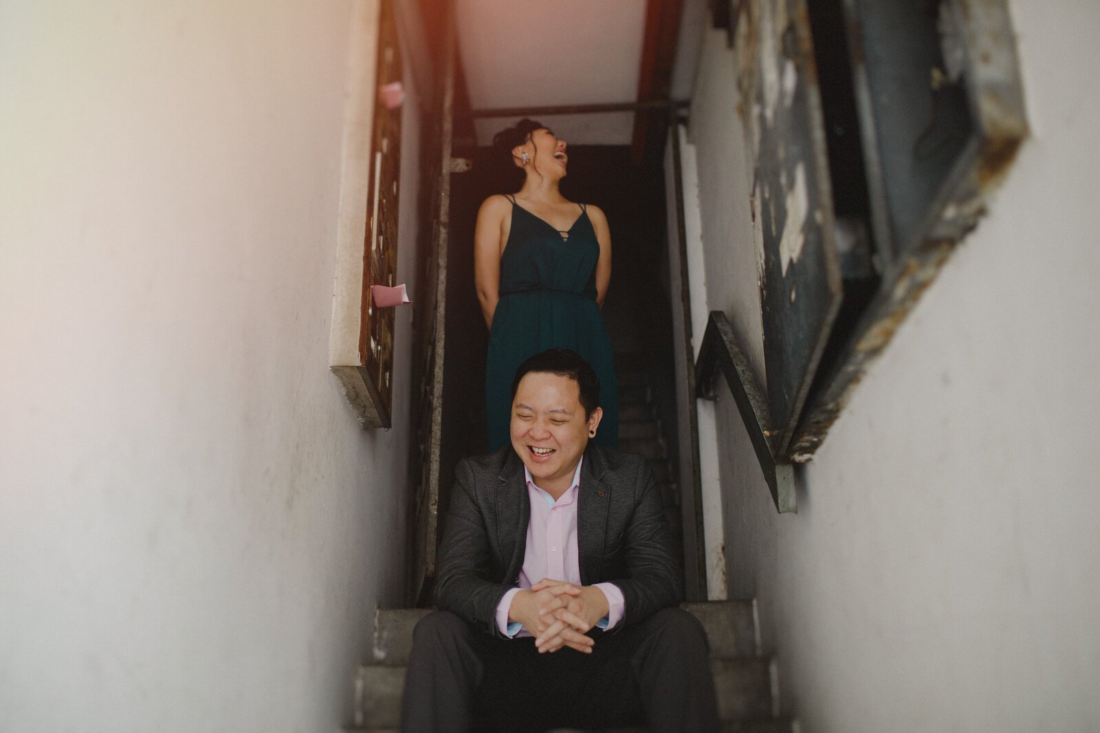 Couple laughing on the staircase of a apartment