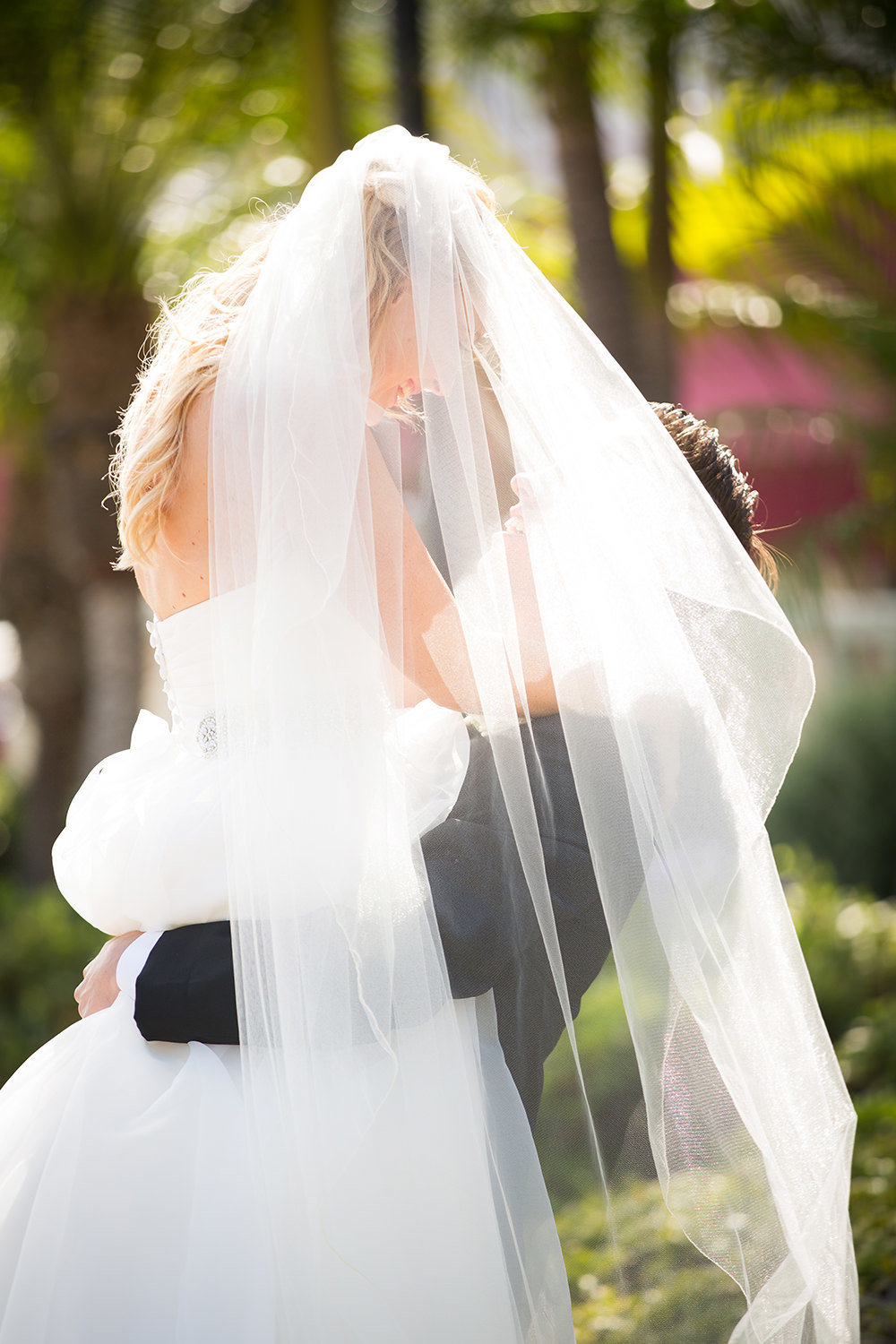 Great moment of groom lifting the bride with flowing veil