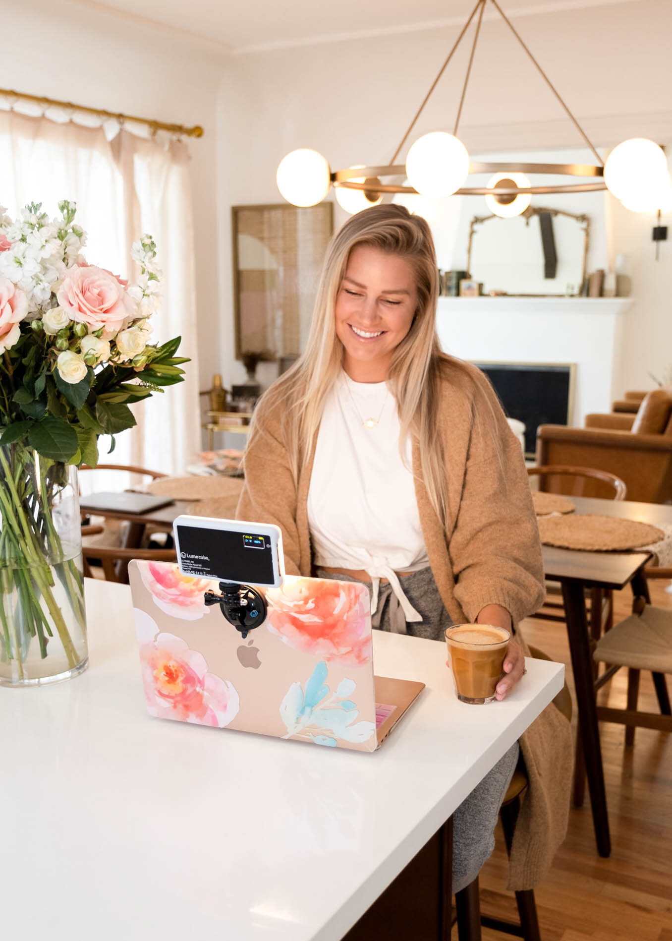 Travel blogger The Blonde Abroad Kiersten Rich on a video skype call branding portaits laptop in the dining room