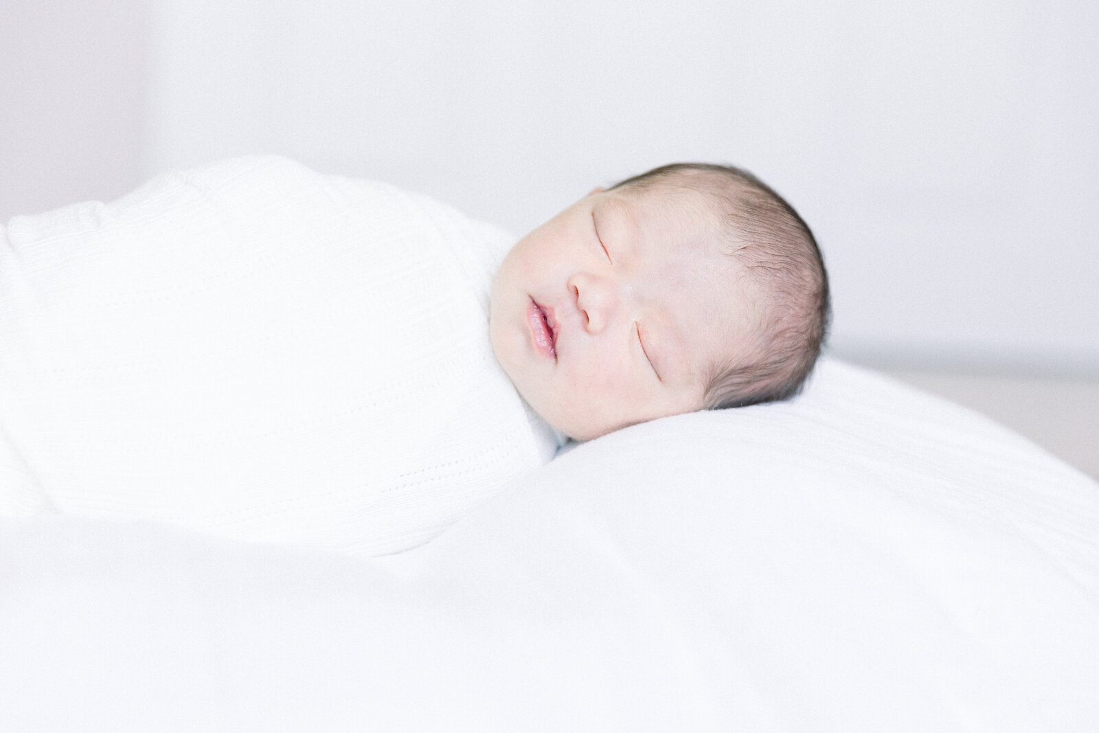 Image of sleeping baby with head on white pillow  close up taken by Newborn Photographer Sacramento Kelsey Krall