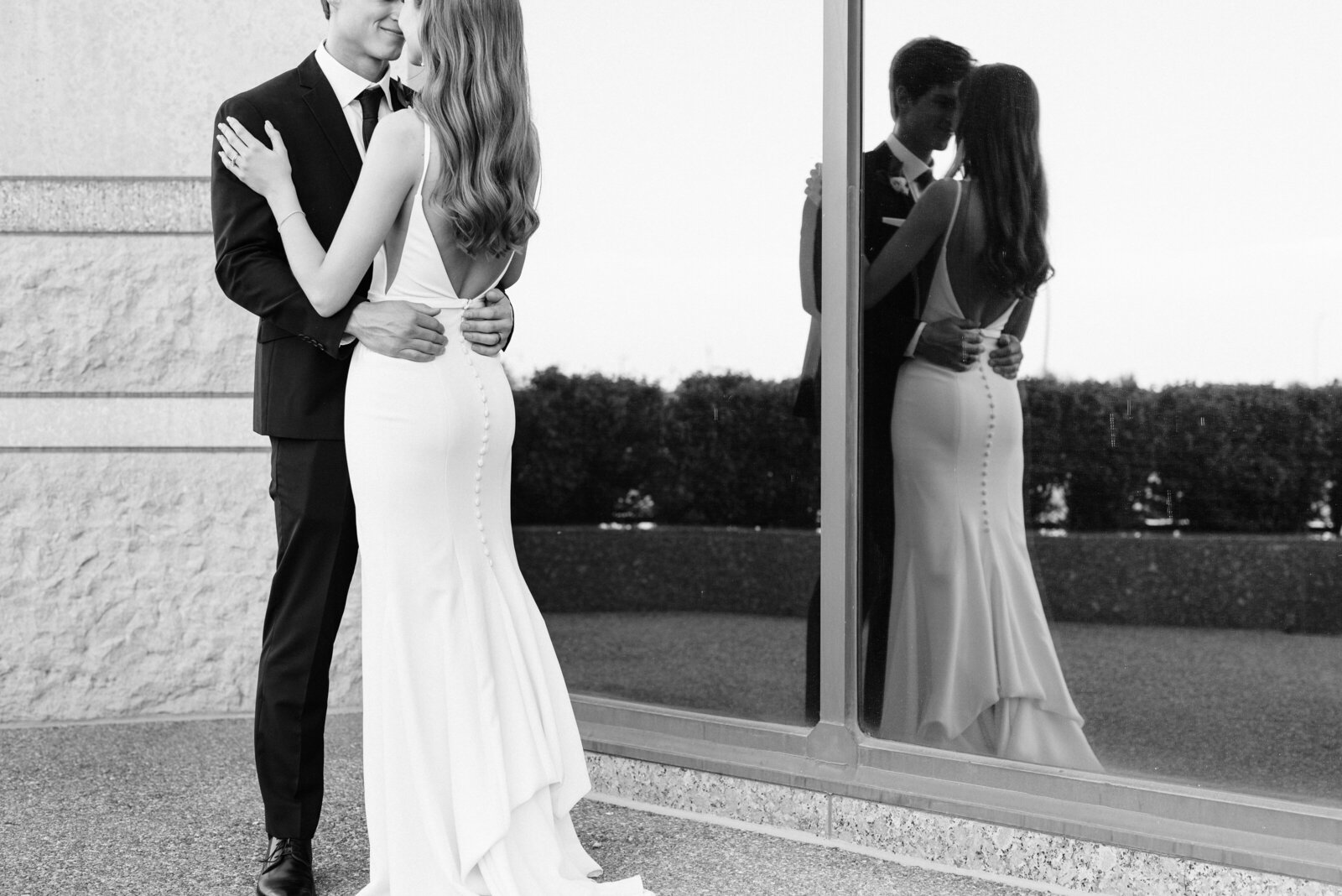 Wedding couple standing in front of a large window with reflection