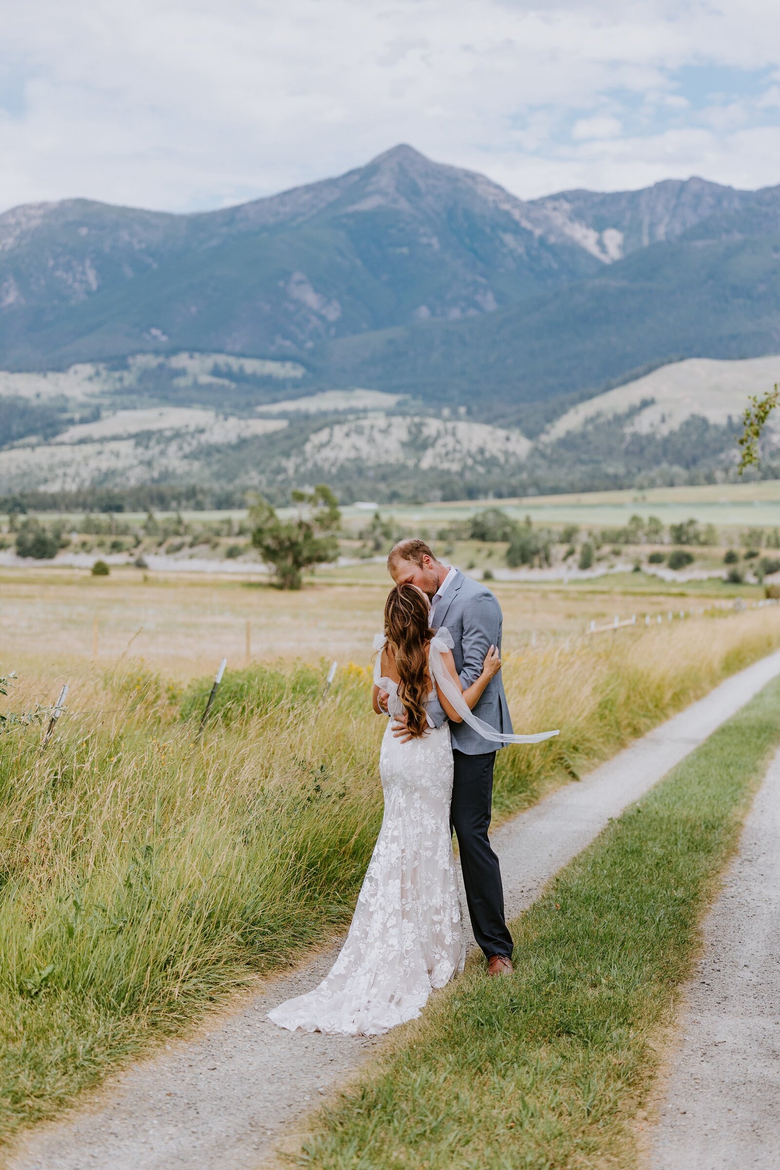 Couple kiss as they walk down a dirt road in Bozeman.