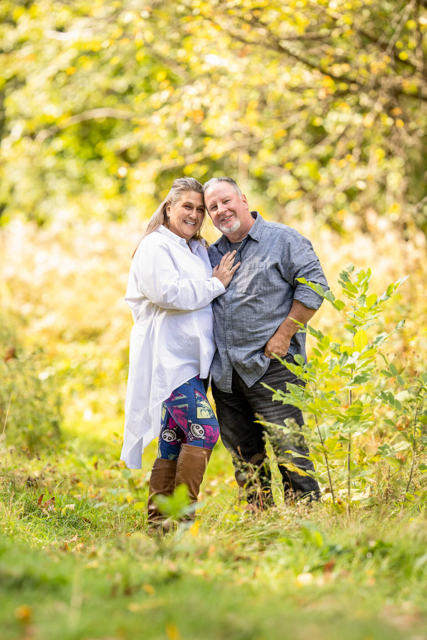 Male and female couple standing in woodland hugging