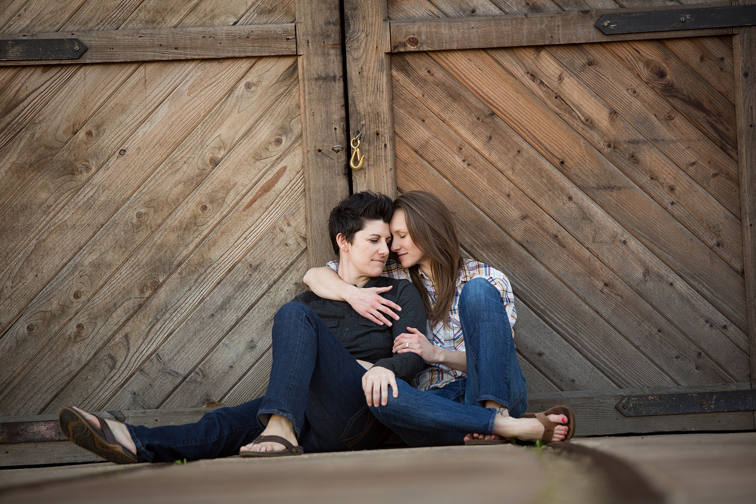 Lesbian engagement session in front of barn door