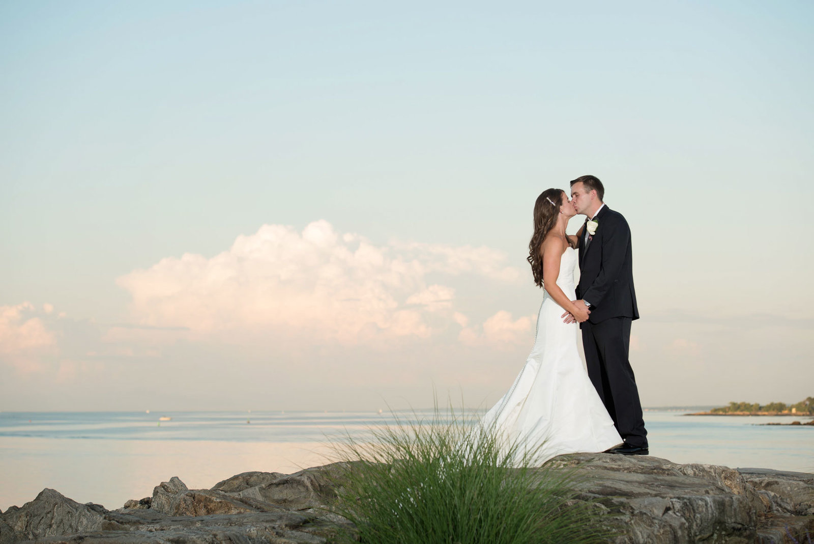 bride and groom kissing by the water at Glen Island Harbor Club