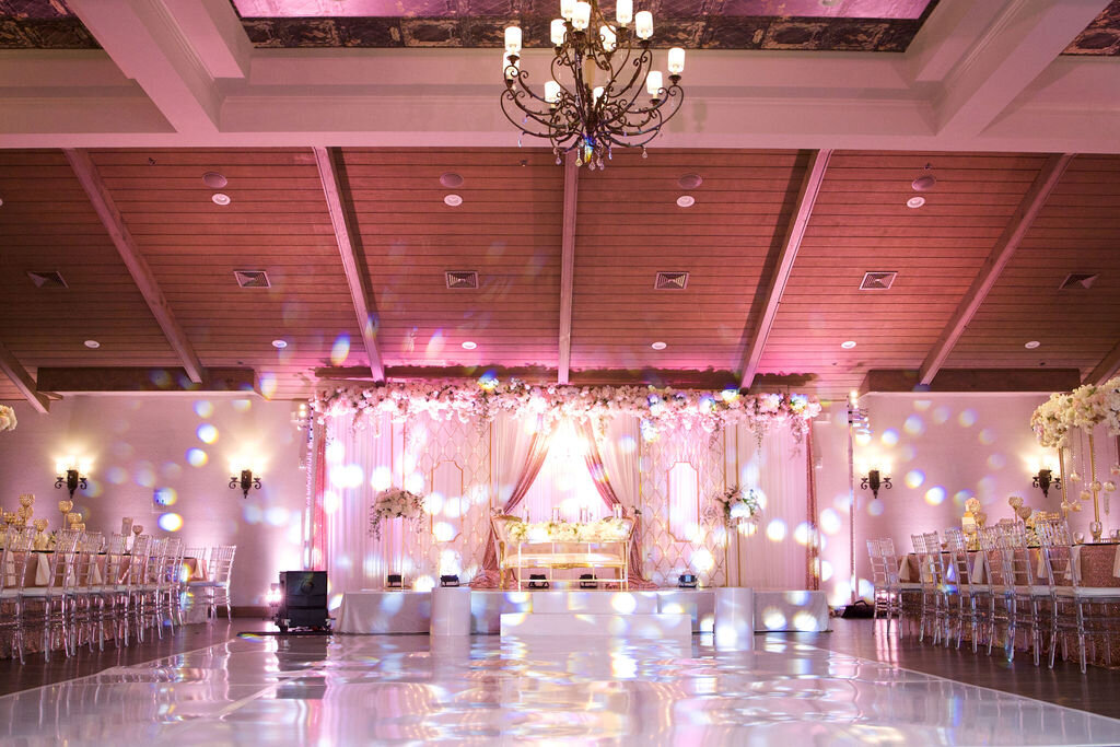 Grand wedding reception with pink lights and tapestries